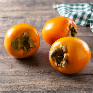 Fresh persimmon fruit on wooden table