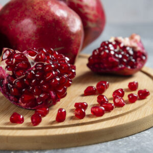Sliced ripe pomegranate on a wooden board. High quality photo